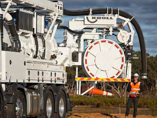 Bucher Municipal Kroll combination unit truck with an operator standing beside it