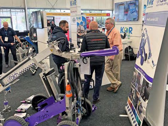 Visitors looking at purple robotic cleaning equipment on an exhibition stand